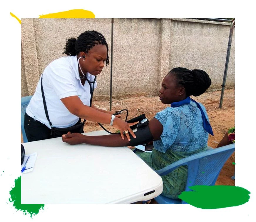 A nurse weighing a child at an outreach.